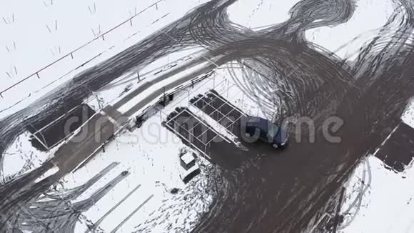 从无人驾驶飞机在驾驶范围内的俯视图与汽车练习驾驶汽车以获得驾驶执照冬天的雪地视频的预览图