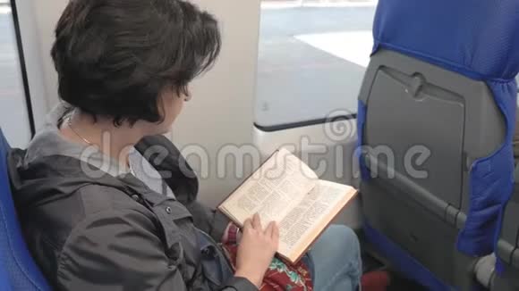 火车是靠窗开的考卡西安女士正在看书看窗外视频的预览图