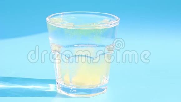 泡腾片在一个玻璃与水的蓝色背景视频的预览图