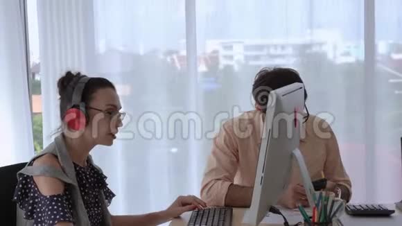 一个商人在工作的时候用电脑和耳机听音乐快乐地工作快乐的商业团队快乐的朋友视频的预览图
