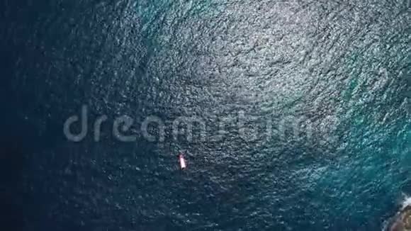 从上面的船上俯瞰游艇漂浮在海洋跑道上或者游船矗立在蔚蓝的海水和珊瑚礁上视频的预览图