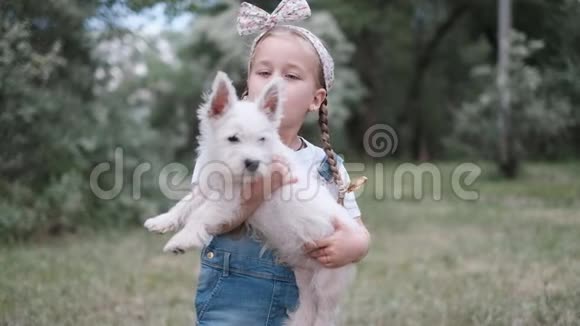 小金发女孩抱着西高地白梗小狗在公园视频的预览图
