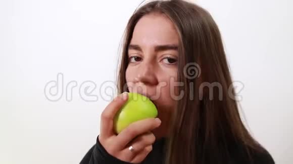 年轻漂亮的女孩咬了一个绿色的苹果视频的预览图