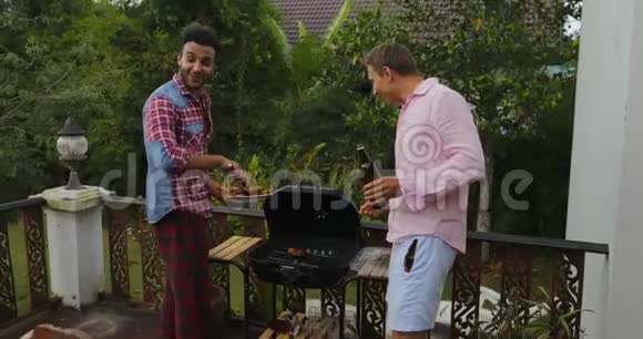 两个人从烧烤的人那里拿食物坐在餐桌前年轻的朋友在夏天的露台上聚会视频的预览图