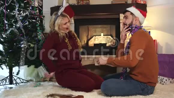 笑容可掬的白人金发女子向可爱的丈夫或男友赠送圣诞礼物的侧视图惊讶的人视频的预览图