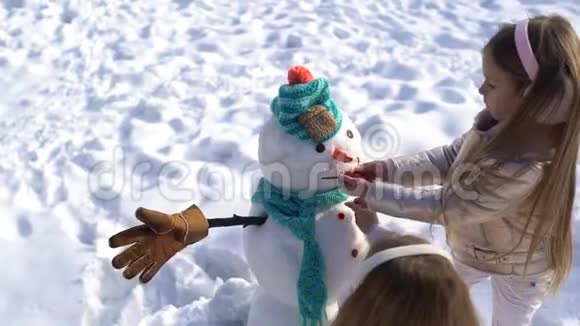 快乐的孩子们在下雪的冬天散步时堆雪人主题圣诞假期冬新年冬天快乐视频的预览图