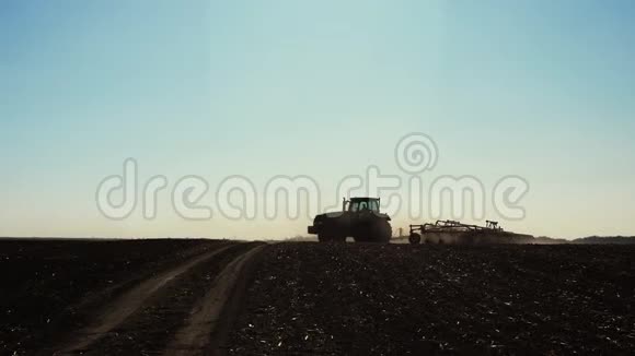 带耕机的拖拉机在田间转动视频的预览图