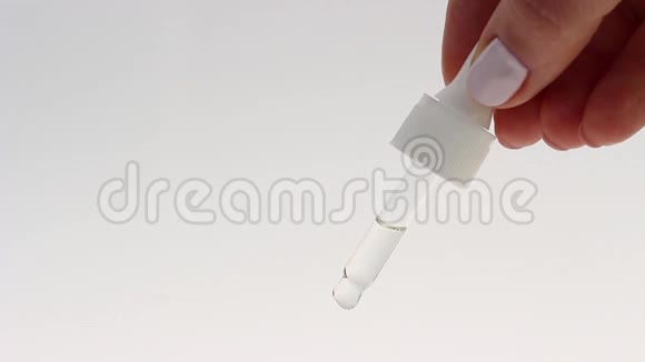 女性手拿着滴管白色背景上有血清特写视频的预览图