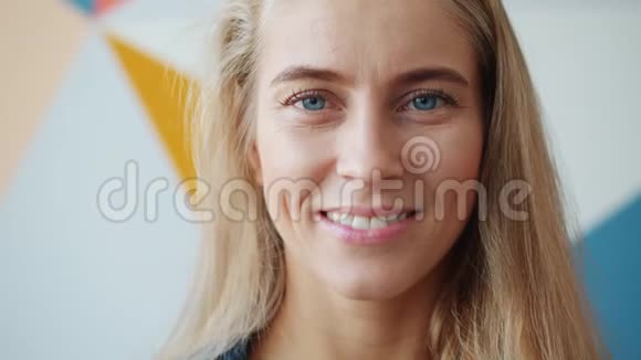 一幅独特女孩的特写肖像蓝眼睛和金发在室内微笑视频的预览图