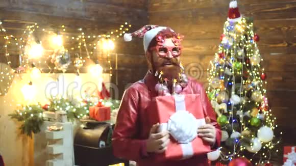 圣诞老人送礼物圣诞派对家里的圣诞老人圣诞老人留胡子的嬉皮士做个滑稽的表情视频的预览图