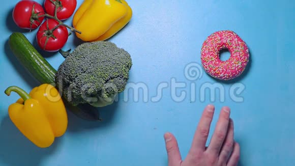 男性的手在蔬菜和甜甜圈之间选择吃新鲜的西兰花视频的预览图