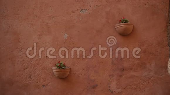 两个挂在墙上的陶瓷花盆红色中提琴挂在古老的橙色墙上意大利视频的预览图