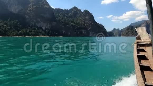 泰国木制窄小船驶向美丽的岩石海岸视频的预览图