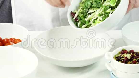 女人把新鲜的绿色沙拉拌在碗里一步一步地做蔬菜沙拉视频的预览图
