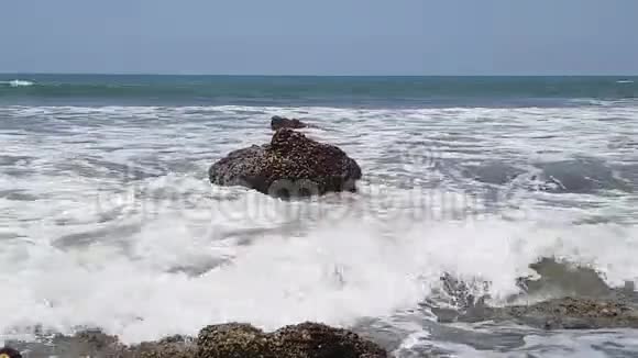 海浪拍打着海岸附近的大海中的巨大岩石视频的预览图