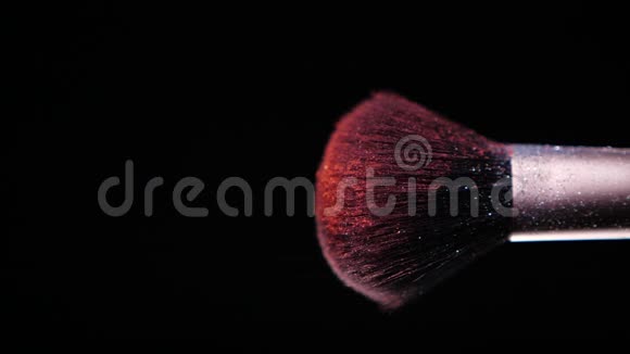 在黑色背景下用彩色红色粉末刷刷慢动作视频的预览图