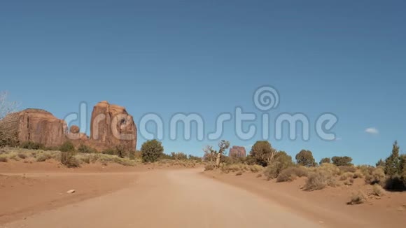 沙漠中尘土飞扬的泥土路在红岩中的运动视频的预览图