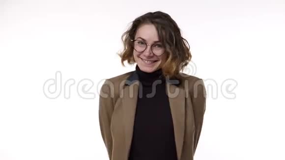 可爱的欧洲女人的肖像特写穿着棕色夹克和时髦的眼镜卷曲的短发摆在上面视频的预览图