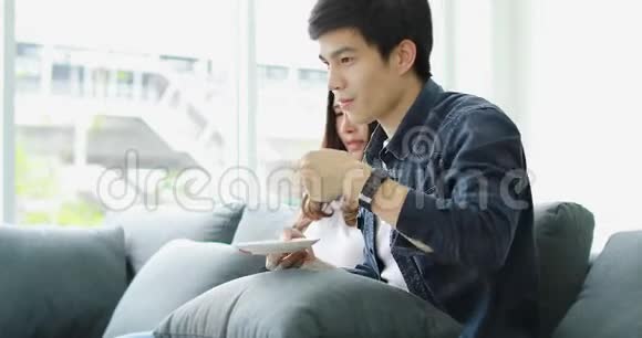 亚洲夫妇坐在沙发上视频的预览图