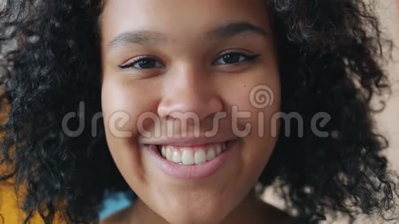 开朗的非裔美国女士的面部肖像微笑着看着室内的摄像机视频的预览图