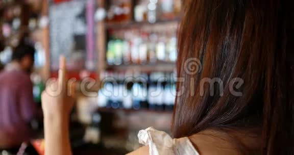 酒吧服务生在吧台与女顾客互动视频的预览图