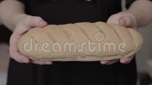 女人的手打破了一个新烘焙的自制甜面包女孩拿着玉米面面包无麸质烘焙健康食品视频的预览图