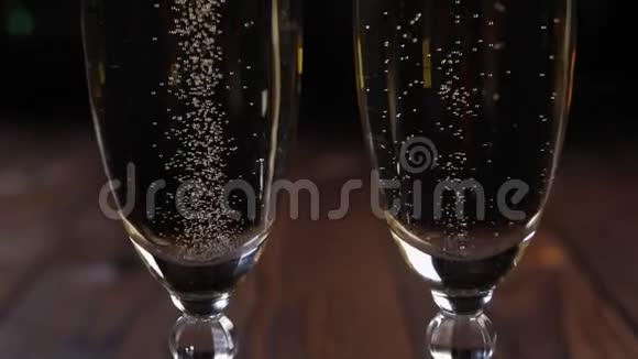 特写两杯香槟黑色背景上有气泡博克视频的预览图