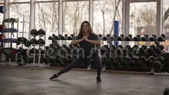 完整的长度镜头年轻美丽和性感的女孩在运动顶部和腿部做侧冲锻炼在锻炼视频的预览图