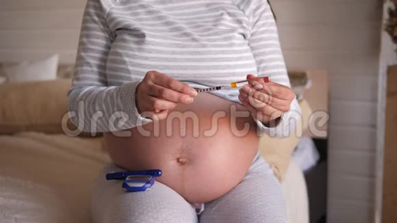 孕妇手持胰岛素注射器和安瓿胰岛素的特写视频的预览图
