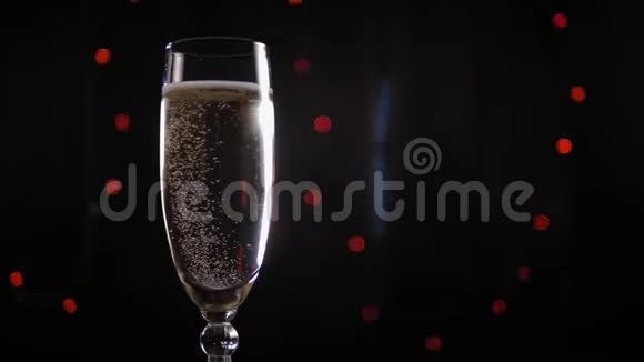 一杯香槟的特写镜头慢慢地在背景中闪烁着灯光视频的预览图