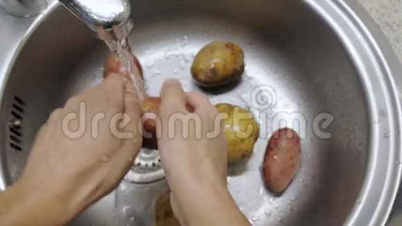 在水槽下洗土豆的人视频的预览图