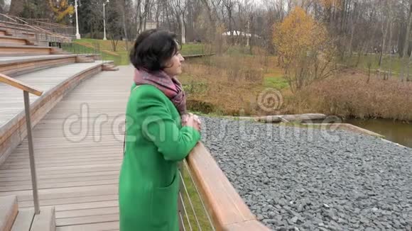 秋高气爽的白种人女子站在大型的木制公园里栏杆已经倾斜了视频的预览图