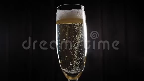 特写一杯香槟放在黑色背景上玻璃缓缓转动视频的预览图