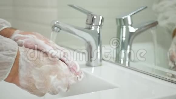 在洗手间用肥皂和水清洗和消毒他的手从病毒中缓慢移动视频的预览图