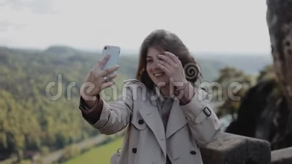 年轻漂亮的女孩在美丽的山景面前自拍特写镜头巴斯蒂瑞士萨克森视频的预览图
