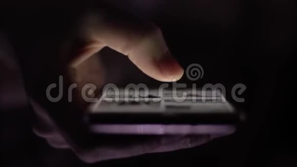 晚上女孩一只手拿着智能手机拇指在屏幕上翻动照片视频的预览图