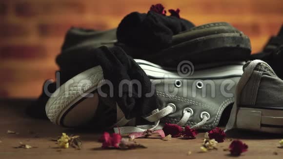 肮脏的运动鞋和袜子堆放在地板上视频的预览图