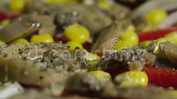 自制纯素披萨配上蘑菇胡椒玉米和橄榄在餐桌上旋转视频的预览图