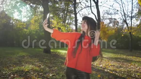 年轻漂亮的女孩朋友们在秋天金色树叶的背景下在美丽的公园自拍视频的预览图