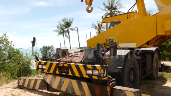 在热带森林工作的建筑机器黄鹤在热带砍伐外来树木的侧景视频的预览图