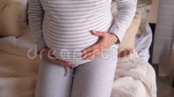 一个孕妇的特写她的肚子在家里的卧室里视频的预览图