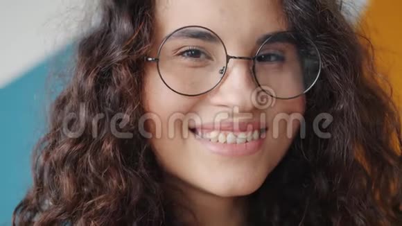 一位戴着眼镜微笑着看着室内摄像机的快乐亚洲女士的特写镜头视频的预览图