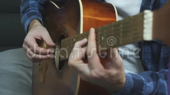 男手用吉他弹奏和弦近距离观看音乐家手演奏的声学吉他视频的预览图