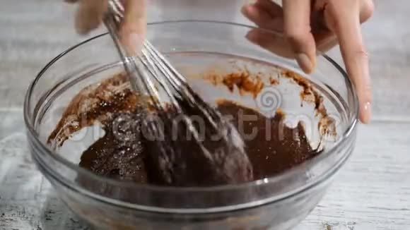 为布朗尼做巧克力面团搅拌可可面团混合物加入榛子视频的预览图