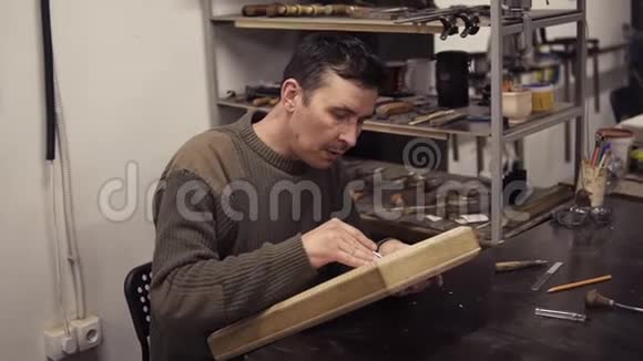 白种人接头用弯曲的凿子在木制工件上做缺口一位雕刻木制装饰品的工匠视频的预览图