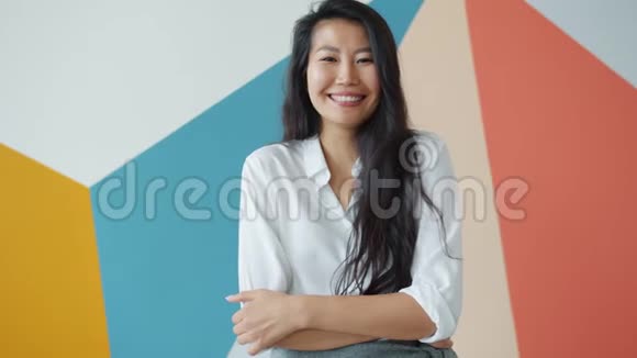 快乐的亚洲学生在五颜六色的背景下笑着慢动作视频的预览图