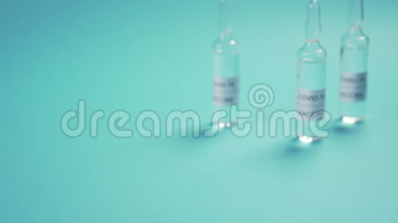 冠状病毒疫苗一只手戴着医用防护手套在蓝色的表面的安瓿视频的预览图