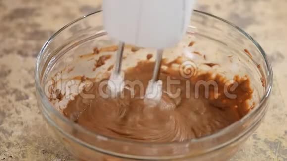 用巧克力搅拌黄油为蛋糕做棕色巧克力奶油视频的预览图