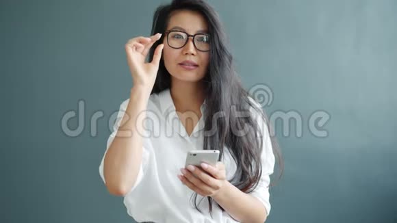 年轻的女商人使用智能手机触摸屏幕灰色背景视频的预览图
