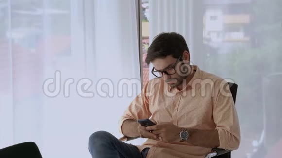 那个英俊的白人坐着用手机态度轻松视频的预览图